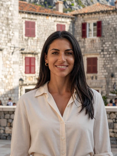 Dušica, 33-year-old Montenegrin woman from Kotor with dark hair near old town stone walls