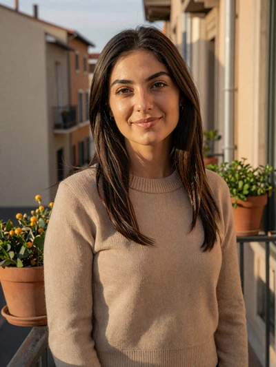 Anila, 29-year-old Albanian woman from Tirana with dark brown hair and warm smile on sunlit balcony