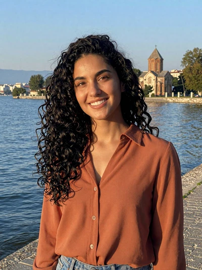 Kalina, 28-year-old Macedonian woman from Ohrid with curly black hair on lakeside promenade